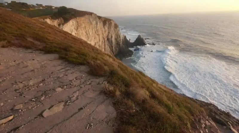 Una escena emotiva en un acantilado al amanecer